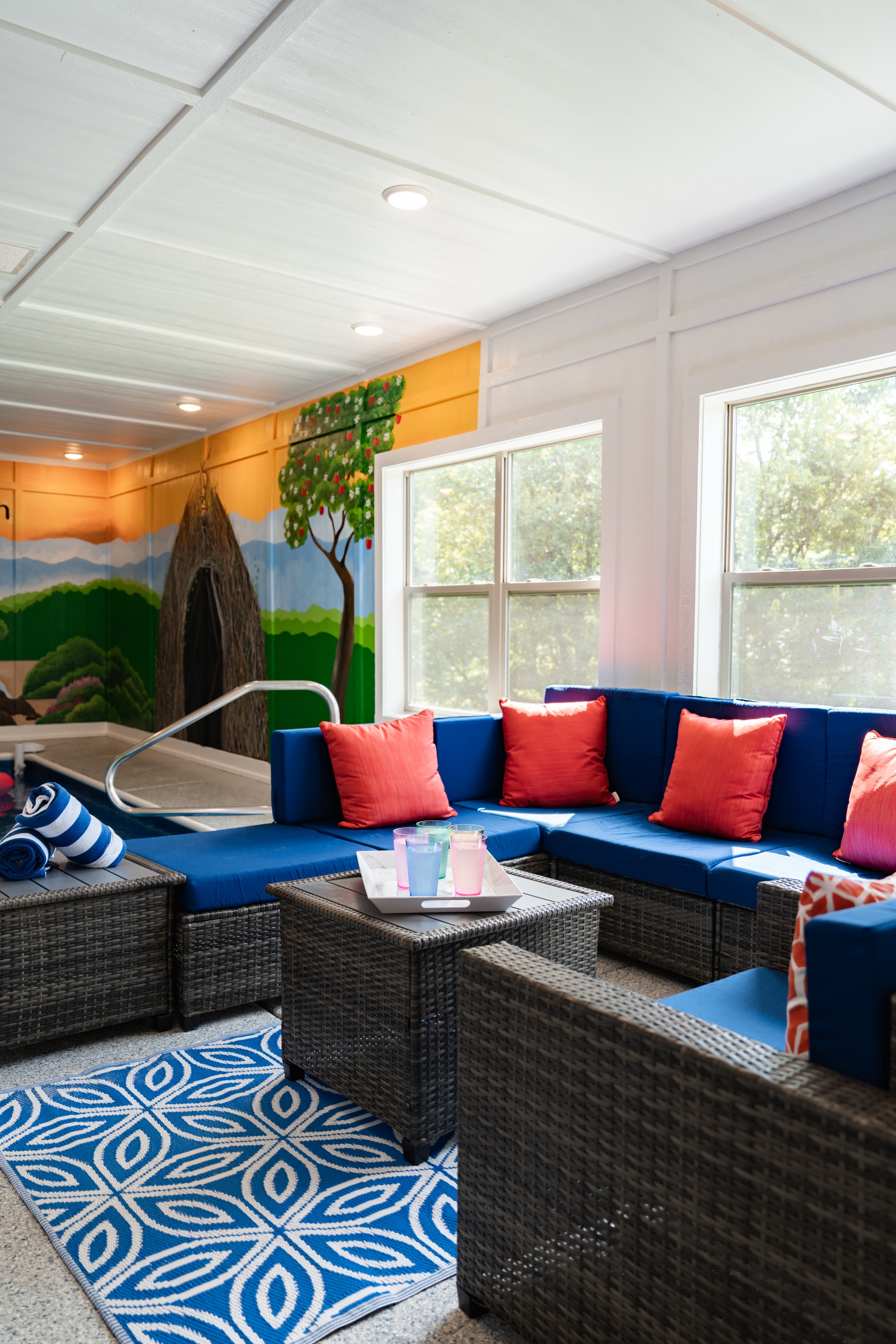 Wide view of indoor pool with Sasquatch mural and basketball hoop